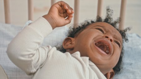 bebe llorando sobre su cuna