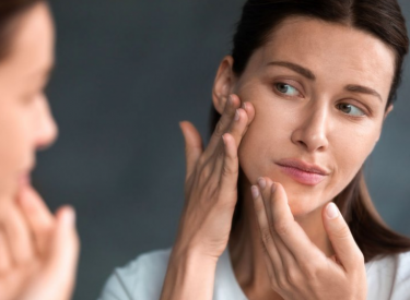 Mujer revisando su piel en la zona facial
